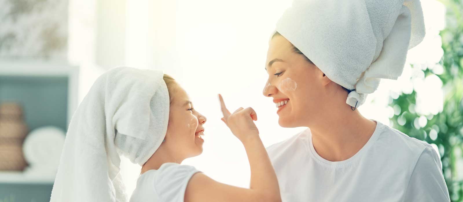 Symbolbild DERMASENCE zeigt eine Mutter mit der Tochter beim Eincremen